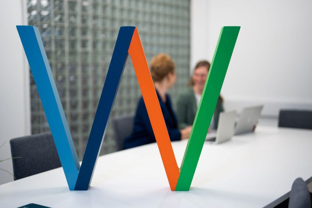 Employees discuss the benefits of artificial intelligence in survey analysis. AI helps group responses, identify emotions, and produce clear summaries of feedback.